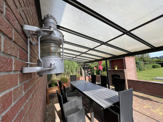 Terrasse mit Markise, Kräuterbeet und Kamin