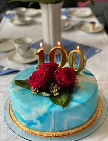 Torte zum 100 Geburtstag mit Kerzen und Blumen